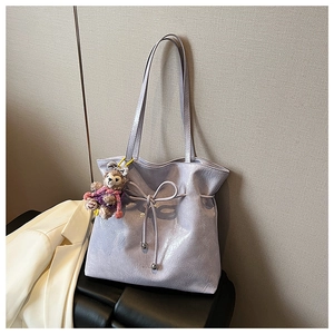 Détail du sac cabas lilas avec texture en cuir plissé et charmant pendentif ours en peluche