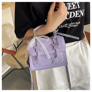Close-up of purple star messenger bag featuring lace bows and embossed fashion text