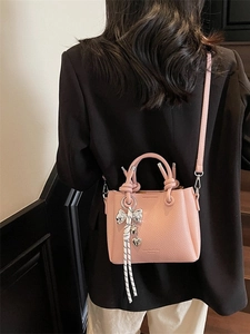 Pink lychee grain leather bucket bag with silver bow charm and shoulder strap