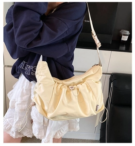 Detail of light beige drawstring tote bag with adjustable buckle strap and nylon texture