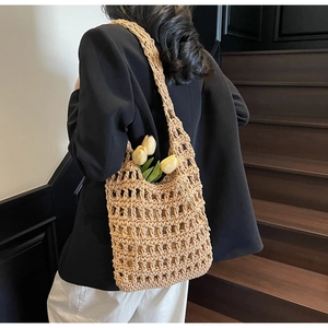 Detalle de bolso de hombro de paja tejida con tulipanes en la espalda de persona