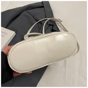 Detailed bottom view of creamy white PU leather handbag with adjustable slim strap