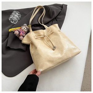 Détail du sac cabas blanc cassé avec cuir froissé et charmant pendentif d'ours