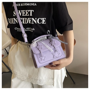 Detail of purple PU leather square bag with star appliques and lace trim on a model