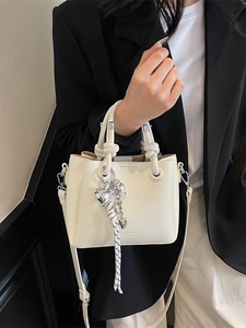 Chic beige bucket bag with lychee pattern leather and heart pendant charm