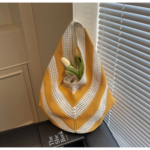Detailed knit texture of a yellow and white striped beach tote bag with hollow design