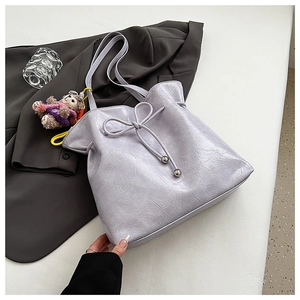 Détail du sac cabas lilas avec texture froissée et pendentif ours en peluche