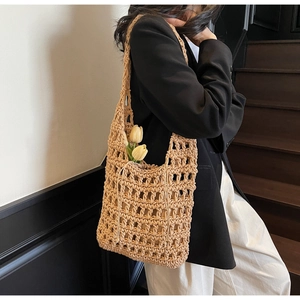 Detalle de bolso de paja trenzada con forro de cordón interior y decoración de tulipanes
