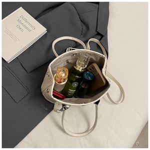 Top view of cream leather tote interior showing large capacity for cosmetics and smartphone