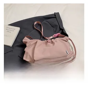 Detailed view of pink nylon tote bag featuring drawstring pleats and plastic buckle