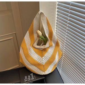 Detailed close-up of yellow and white striped knit tote with hollow crochet texture