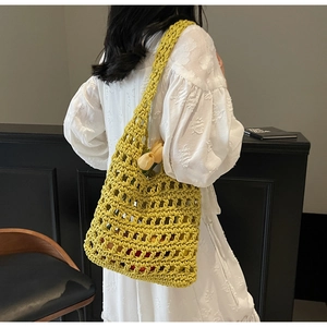 Detalle de bolso de ganchillo amarillo hecho a mano con flores sobre vestido blanco
