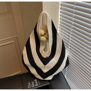 Detailed close-up of black and white V-stripe crochet pattern on a large knit beach bag