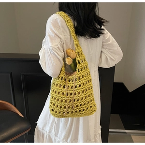 Detalle del bolso tipo cesta de punto amarillo con malla ancha y bolsa interior de tela