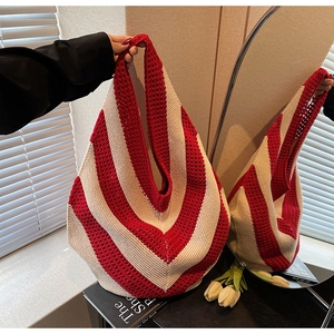 Macro shot of the vibrant red and beige striped crochet pattern on the knit tote bag