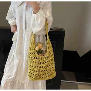 Detalle del bolso tipo cubo de ganchillo amarillo con una bolsa interior marrón ajustable