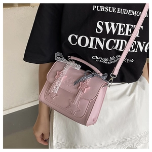 Detailed side view of a pink star messenger bag with lace and checkered bow accents