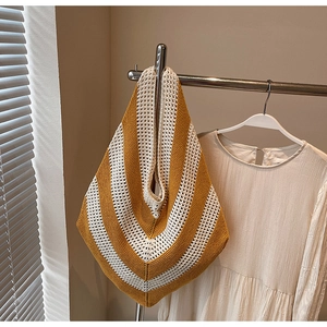 Close-up of hand-woven yellow and white chevron knit pattern on a large beach tote bag
