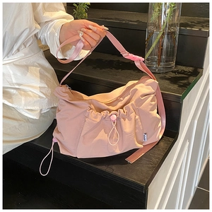 Detail of the light pink nylon tote bag showing drawstring ruffles and adjustable strap