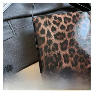 Close-up of glossy leopard print patent leather fabric on a trendy underarm bag