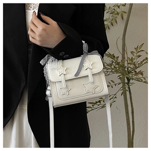 Detail of white star messenger bag with lace ribbon and black blazer contrast view