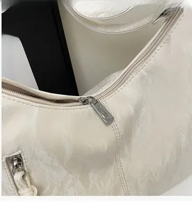 Detail of silver zipper hardware on premium white marble-textured PU leather bag