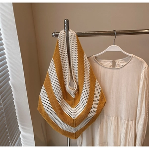 Detailed knit texture of large hobo bag with yellow and cream V-shaped stripes
