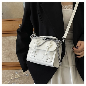 Detailed view of a white messenger bag with star patch and checkered ribbon bow accessory