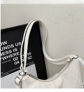 Detail view of the cream pleated shoulder bag showing comfortable handles and durable texture