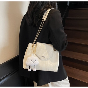 Close-up of marble texture leather shoulder bag with gold chain and cloud pendant
