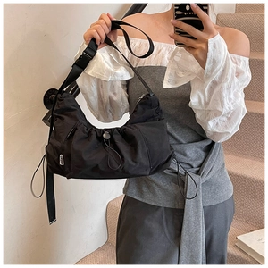 Detail of black nylon crescent tote bag with drawstring ruffles and adjustable buckle strap