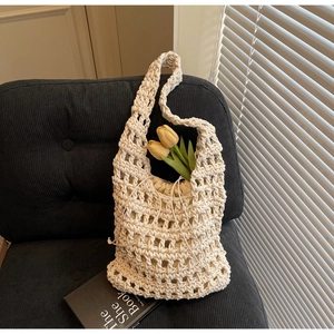 Detalle del bolso tejido crema con patrón calado y bolsa interior con cordón ajustable