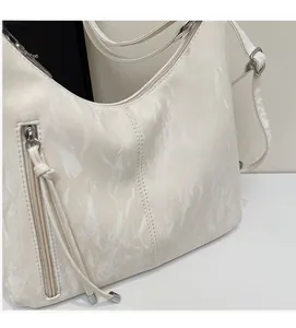 Close-up of white marble pattern shoulder bag with side zipper and premium stitching