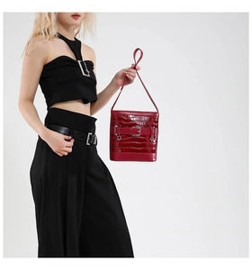 Détail du sac seau rouge foncé avec motif crocodile brillant et boucle métallique