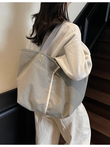 Minimalist grey canvas tote bag for women with large capacity shown in a stylish studio setting