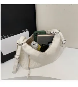 Interior view of white pleated shoulder bag showing space for phone, notebook and umbrella