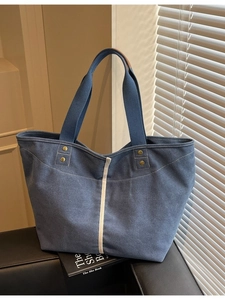 Minimalist denim blue canvas tote bag with white vertical stripes and sturdy web handles