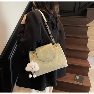 Detail of mint green ruched leather shoulder bag with gold chain and cloud charm