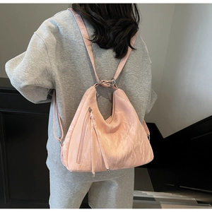 Rear view of a pink pleated leather backpack on model showcasing its soft pearly texture