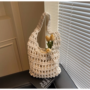 Detalle del bolso de paja beige de ganchillo con forro interior de cordón y malla