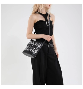 Détail du sac seau à imprimé zèbre avec finitions en cuir noir et boucle en argent