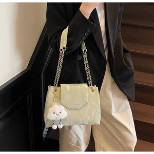 Detail of light green marble texture bag with gold chain strap and cloud charm