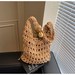 Detalle del bolso beige tejido a mano con textura de ganchillo y bolsa interior