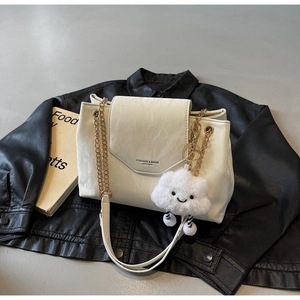 Close-up of white marble texture shoulder bag with gold chain and plush cloud charm