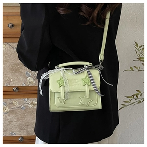 Detail of mint green PU leather star bag with lace bow and adjustable shoulder strap
