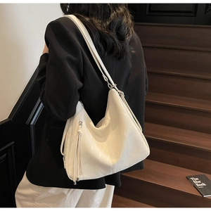 Fashionable creamy white large capacity hobo bag with soft leather texture on a shoulder