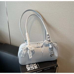 Close-up of light blue patent leather bowling bag with lace bows and heart pendant