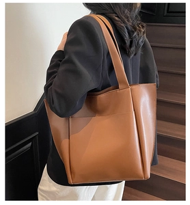 Side view of a brown leather tote bag showing large capacity and smooth texture detail