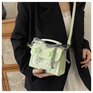 Detail of light green star crossbody bag with lace bow and happiness embossing