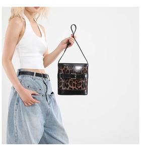 Détail du sac seau à imprimé léopard avec une sangle ornée d'œillets métalliques